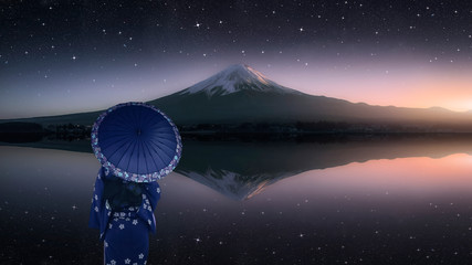 Girl with traditional dress look at Mount Fuji from Kawaguchi lake in evening 