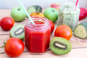 Tomato juice and cucumber smoothies in a glass jar with vegetables. Healthy background