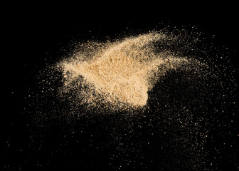 Sand splash explosion on dark black background ,throwing freeze stop motion object design