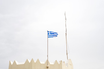 Greek national flag on flagpole waving against blue sky, Kos, Greece