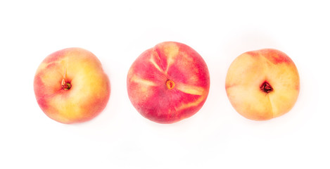 Vibrant organic flat saturn peaches, shot from the top on a white background