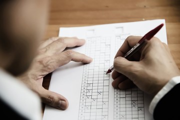 Instructor checking multiple choices answer sheet exam - education people working with paper test concept