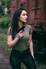 Fototapeta premium Powerful Woman Holding Gun Action Movie Style. Train adventure. Military girl with .