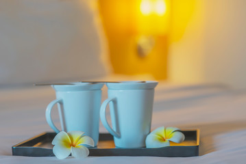 Close up of twin welcome coffee cup on white bed in hotel room - hotel well hospitality vacation travel concept