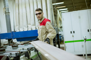 Young man working in the furniture factory