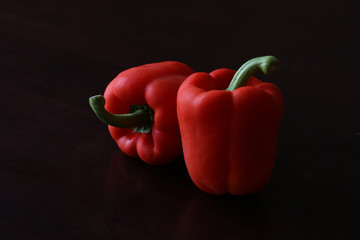 Red capsicum peppers on black background