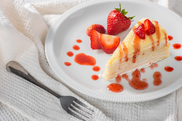 piece of strawberry cake dessert and sauce topping on white dish