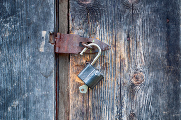 old padlock with keys on old wooden door
