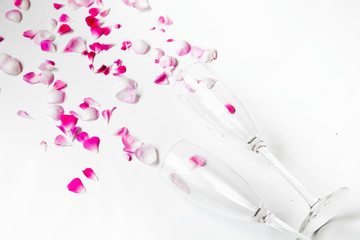 glasses with rose petals on a white background