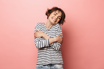 Happy beautiful woman posing isolated over pink wall background.
