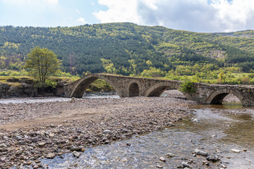 Long old stone bridge over a river