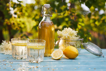 Elderflower lemonade with bottle of syrup and elderberry flowers on wooden table - obrazy, fototapety, plakaty
