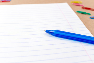 composition with notebook blank page colorful pencil, pen mock-up Back to school concept with stationery office supplies on a brown craft paper background with copy space top view