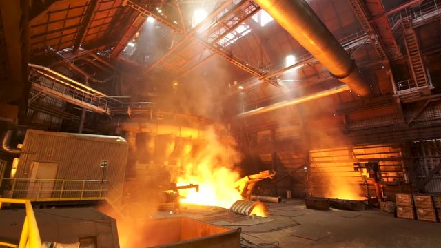 Сasting ingots in foundry shop, metallurgical production. Stock footage. Melting steel at the plant, heavy industry and dangerous work process.
