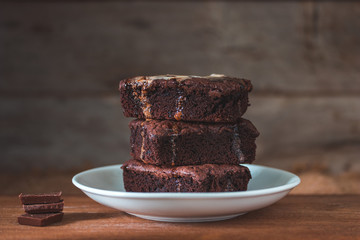 Chocolate brownies stacks on wooden background, homemade sweet and dessert