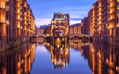 Fototapeta na wymiar Speicherstadt during twilight in Hamburg, Germany, reflection of lights and buildings on water in canal
