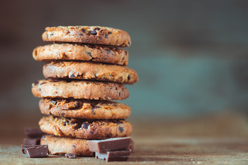 Chocolate chips cookies with crumbs on wooden background, homemade sweet and dessert concept
