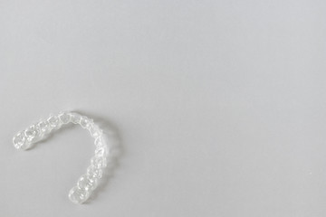 Top view of invisalign braces or invisible retainers on grey background, new orthodontic equipment