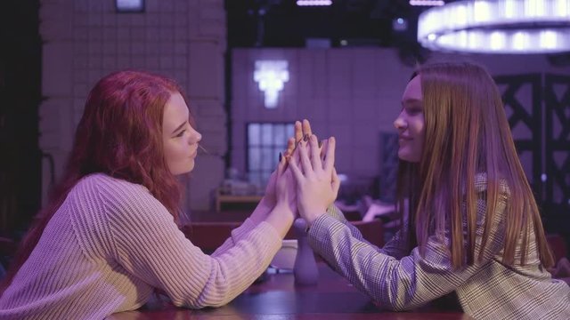 Portrait of two beautiful lesbian couple holding hands in blue light. LGBT love and relationship concept