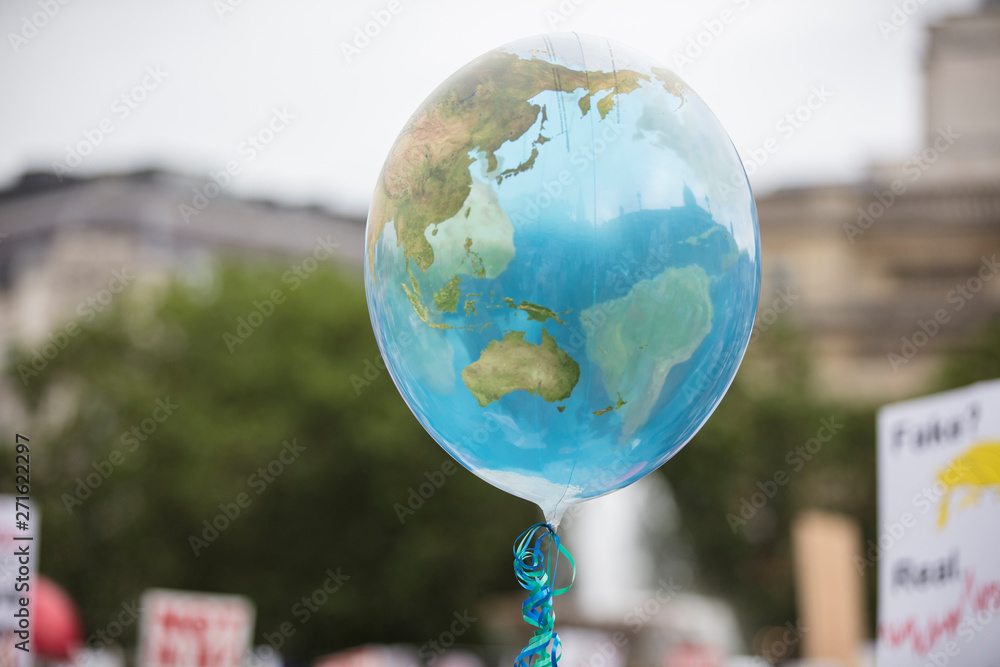 Wall mural an earth shaped balloon floating on a string. climate and environment concept