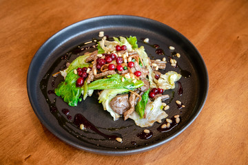 Healthy salad of fresh vegetables, pomegranate seeds and pine nuts