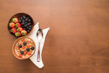 fresh cereal and milk with strawberry and blueberry in bowl beside with spoon and clean cloth, Copy space on the right