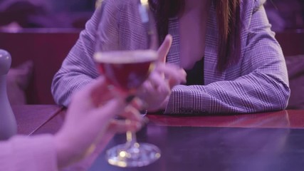Female hand holding glass with alcohol cocktail close up. Unrecognizable woman making refusal gestures, she does not want to drink more alcohol. Unhealthy lifestyle