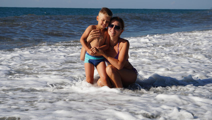 Portrait of the woman with cute baby on the beach