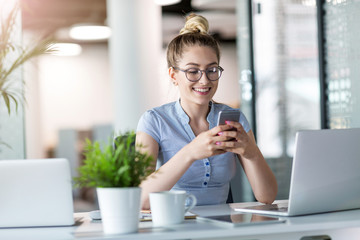 Business woman using smartphone in office