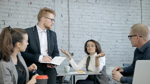 Mature businesswoman discussing new project or strategy with peo