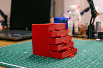 Kropivnitskiy, Ukraine – 12 may, 2018: 3D printed red plastic dresser on the background of laptop...