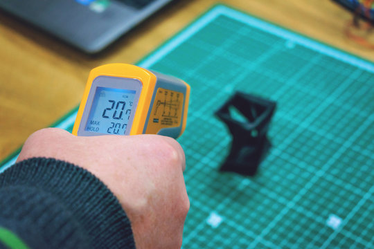 Kropivnitskiy, Ukraine – 12 may, 2018: Laser thermometer. Yellow pyrometer in man hand. Pyrometer, device for measuring relatively high temperatures