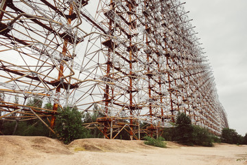 Duga radar system near Chernobyl Nuclear Power Plant after atomic reactor explosion disaster. Destroyed abandoned steel station and ghost city Pripyat ruins. Exclusion zone, lost place.