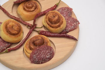 Obraz na płótnie Canvas Salted dough. sliced sausage and chili peppers on a wooden board