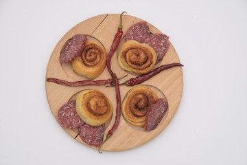 Salted dough. sliced sausage and chili peppers on a wooden board