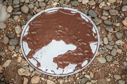 Cover with brown paint. The lid of a can of paint. Paint work. Paint dya wood.