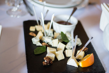 Obraz na płótnie Canvas Cheese in small pieces with skewers on a plate