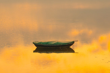 boat laying in water with sunset