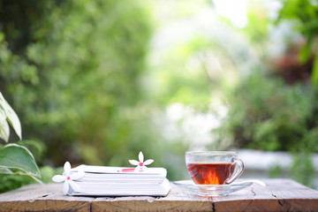 cup of tea with small flower  and notebooks 