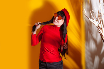 girl hat sun light shadow tropical yellow orange young woman background red glasses