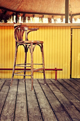 Empty retro wooden bar chair with yellow wooden outdoor bar