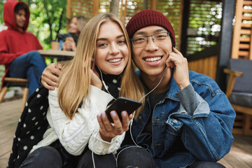 Cheerful multhiethnic couple sitting together