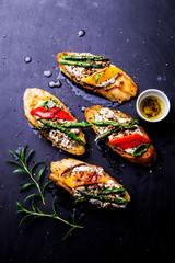 Toasts (sandwiches) with cheese, pepper and asparagus on black
