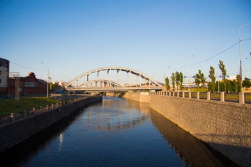 canal with stone walls and arched bridge. sunny day. urban landscape-image