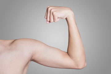 young thin man arm on a grey background.