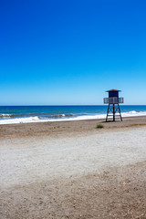 Empty beach with a lifeguard tower at Torre de Benagalbon, Province of Malaga, Andalusia, Spain