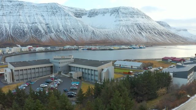 Aerial drone footage of  Isafjordur town in westfjords with impressive mountain ranges surrounding the fjord / inlet of atlantic ocean, Iceland