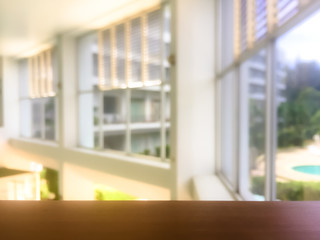 Empty wooden railing with blurred window and light background.