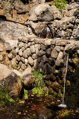 stream of fresh water coming out of a metal spout from a fountain