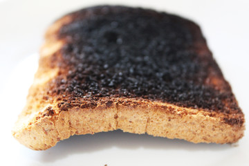 Tostada quemada negra sobre fondo blanco en boke